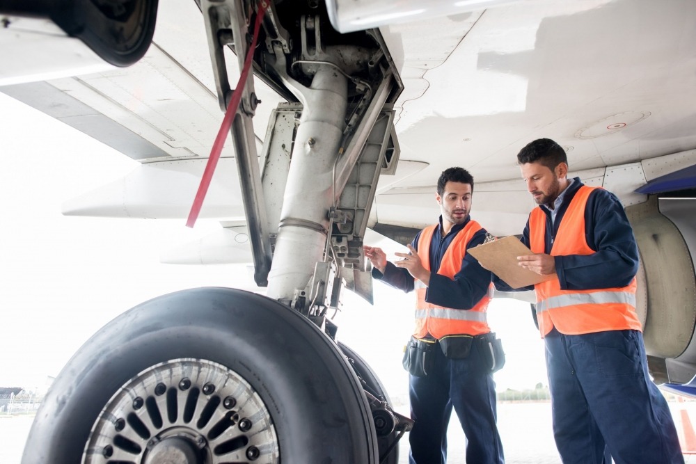 etq reliance aviation safety management employees inspecting plane on tarmac