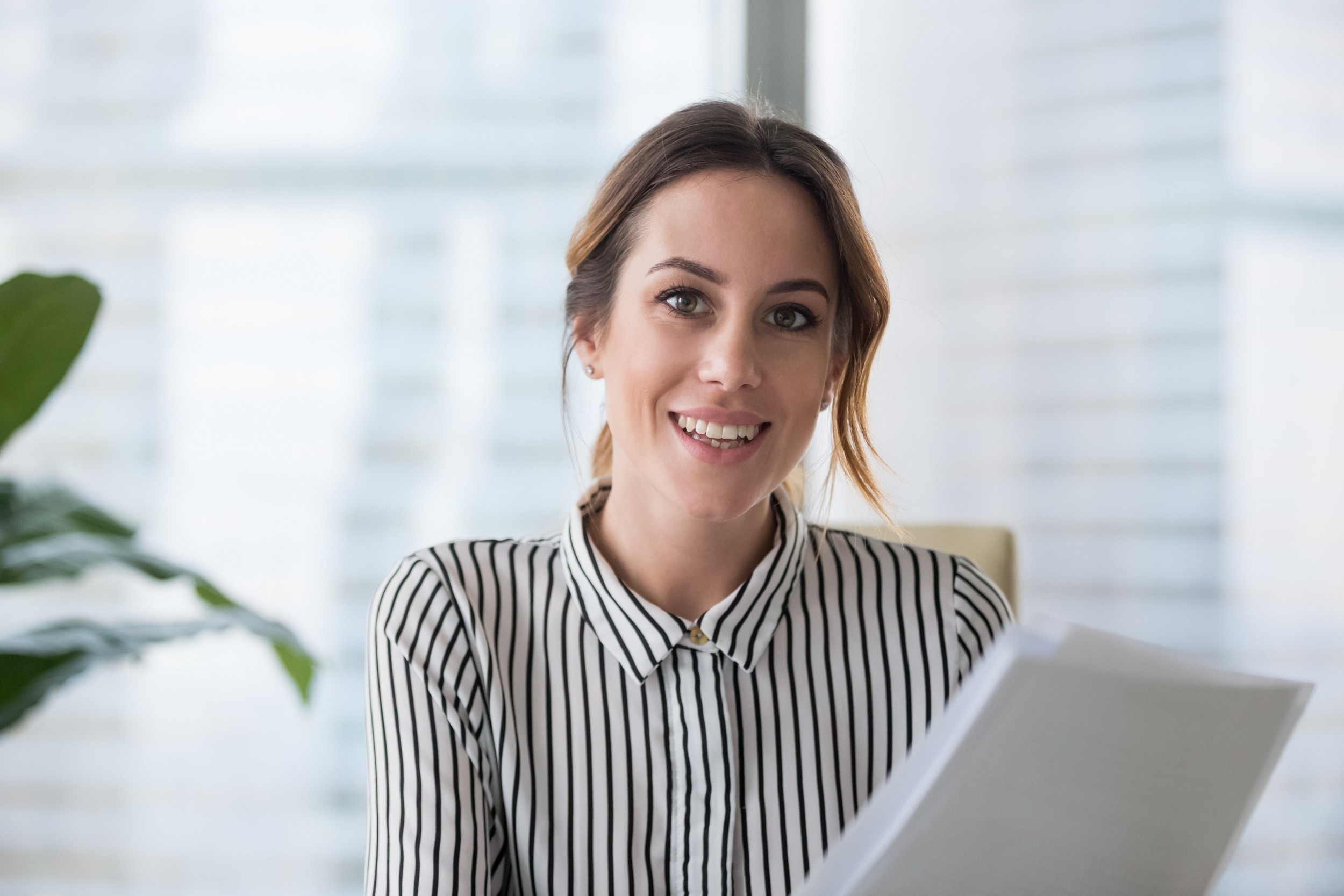 Young quality professional holding report and smiling