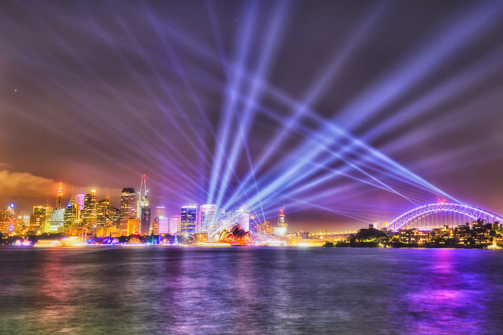 Bright illumination and light show in dark sky over Sydney city CBD, Sydney harbour, The Harbour bridge and major architecture landmarks on waterfront around Circular QUay.