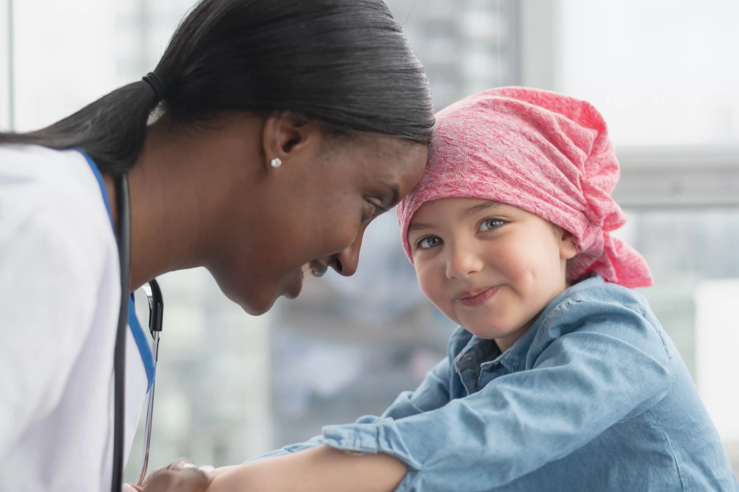 stock image of a doctor who uses medical device QMS software smiling with child patient