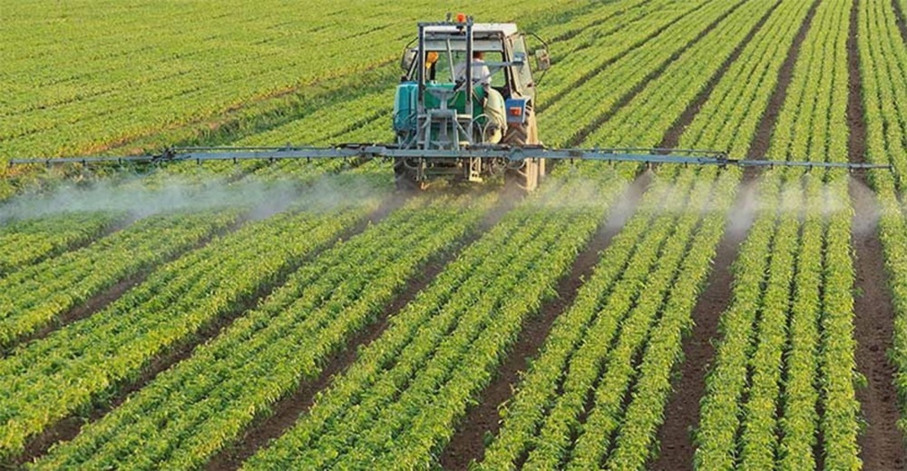 ETQ Reliance Quality Management for Chemical and Agrisciences in field with large tractor spraying chemicals